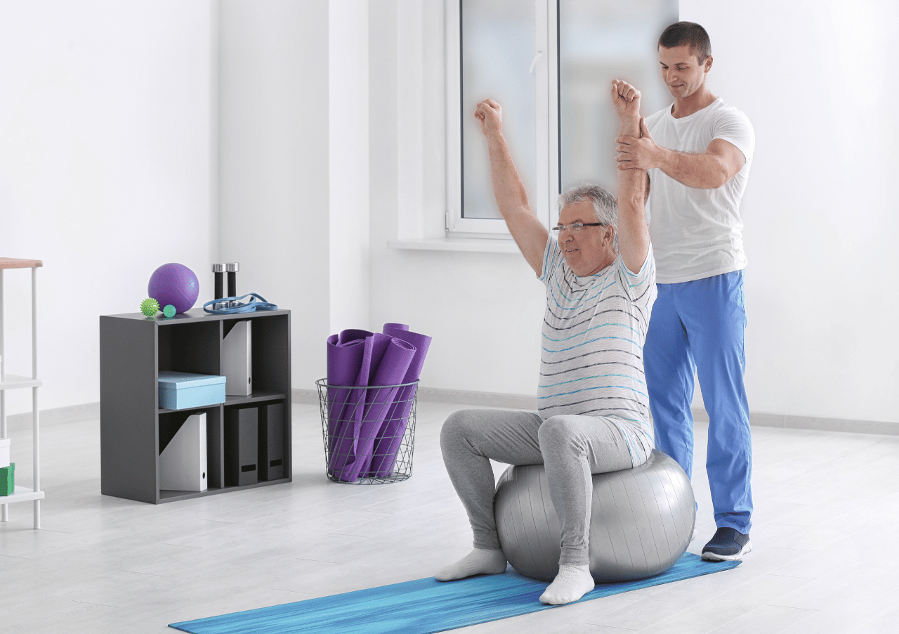 Elderly man stretching with assistance from a physiotherapist