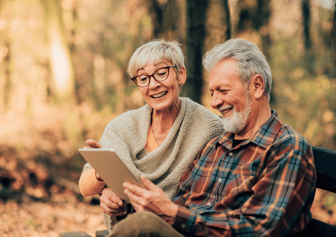 Elderly couple using tablet in park