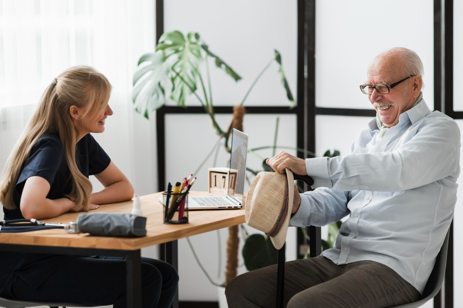 Elderly man smiling with a speech therapist during a home visit