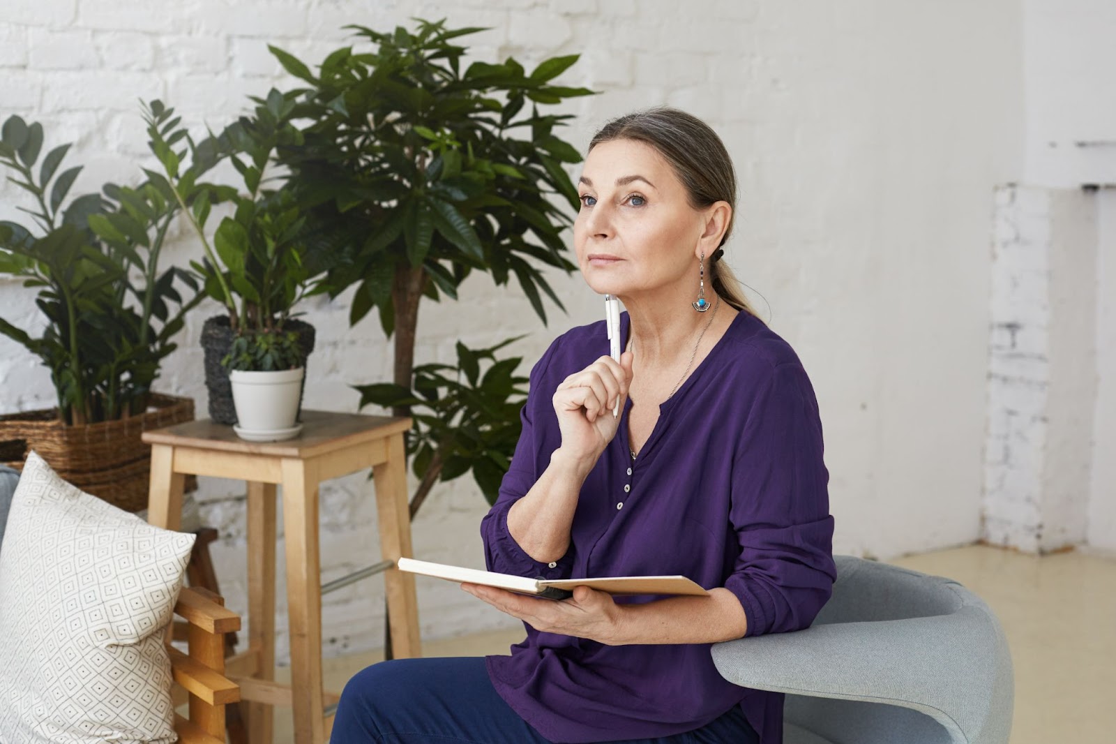 Senior woman thoughtfully journaling at home, elderly home care speech therapy with cognitive and language exercises