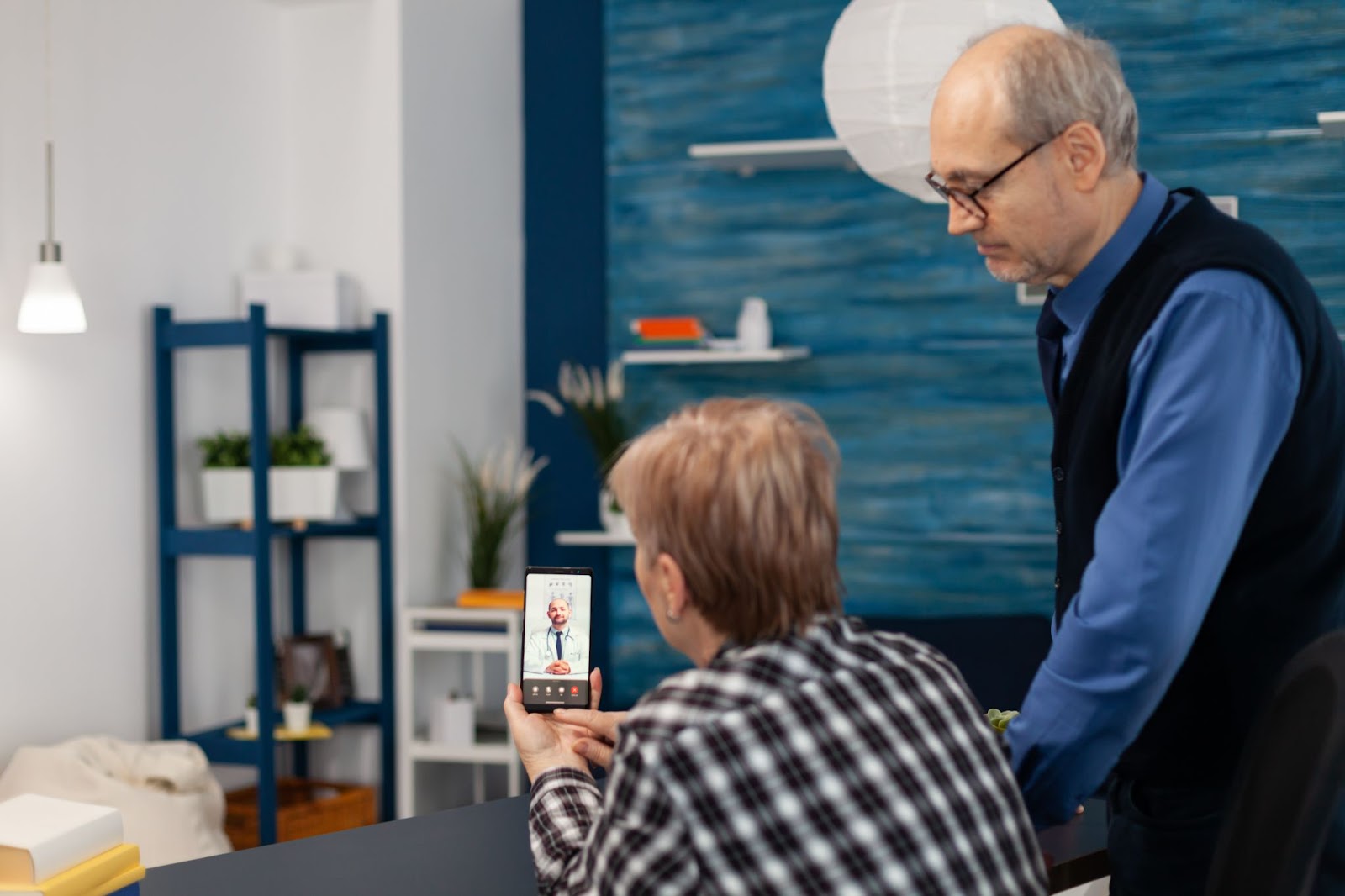 Older couple using smartphone for telehealth aged care video call with remote monitoring aged care support