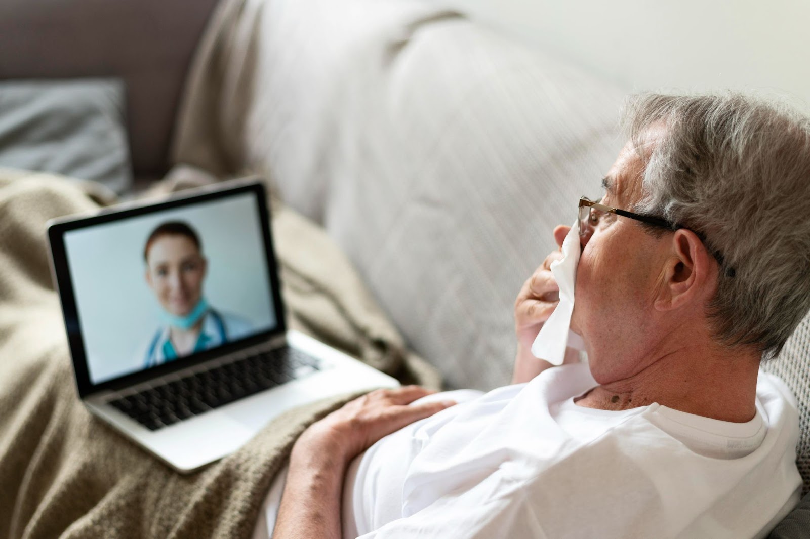 Senior man in telehealth aged care video call from home, demonstrating remote monitoring aged care benefits