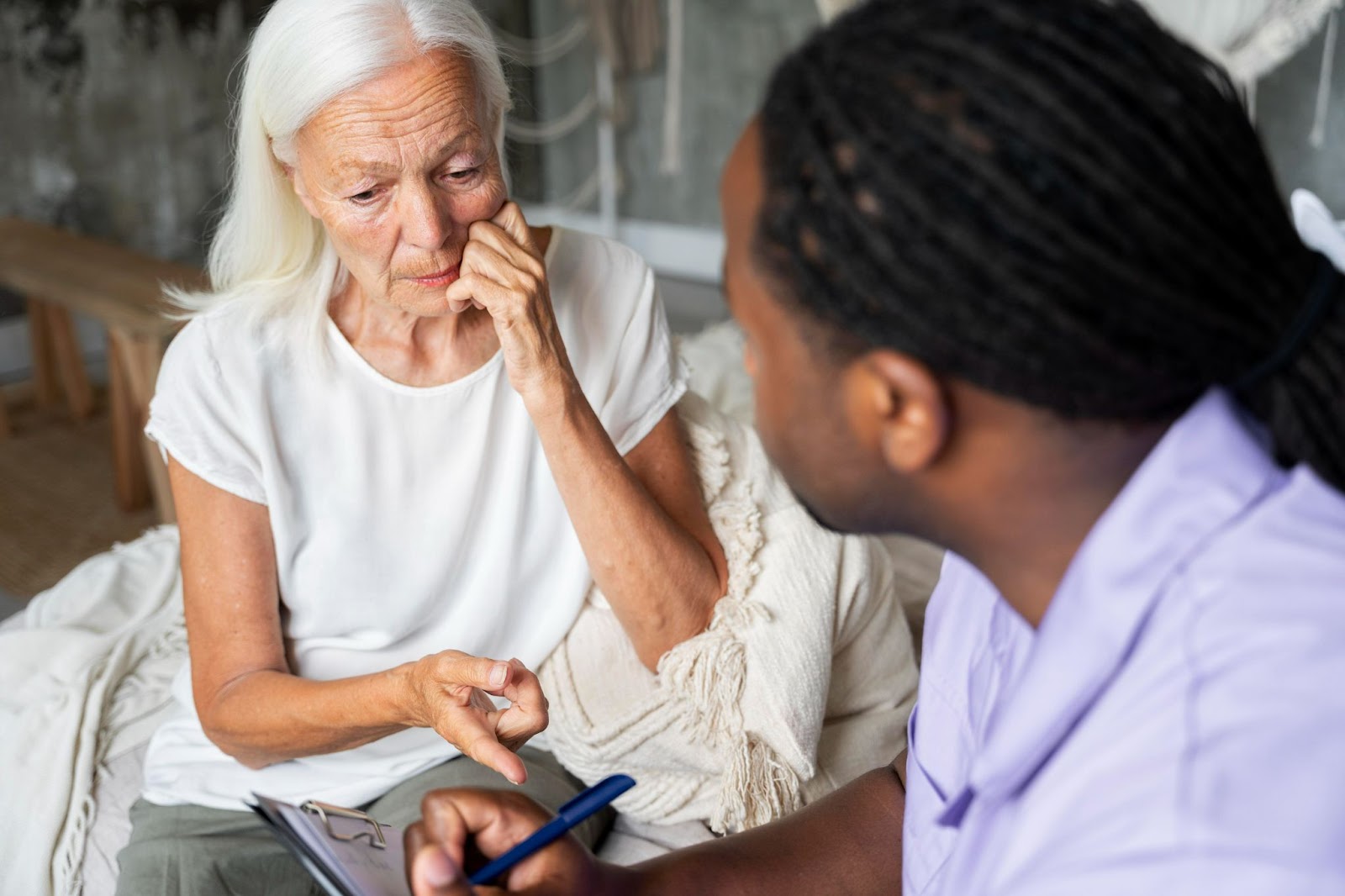 Older woman receiving personalised dementia occupational therapy, discussing with a healthcare professional to support memory