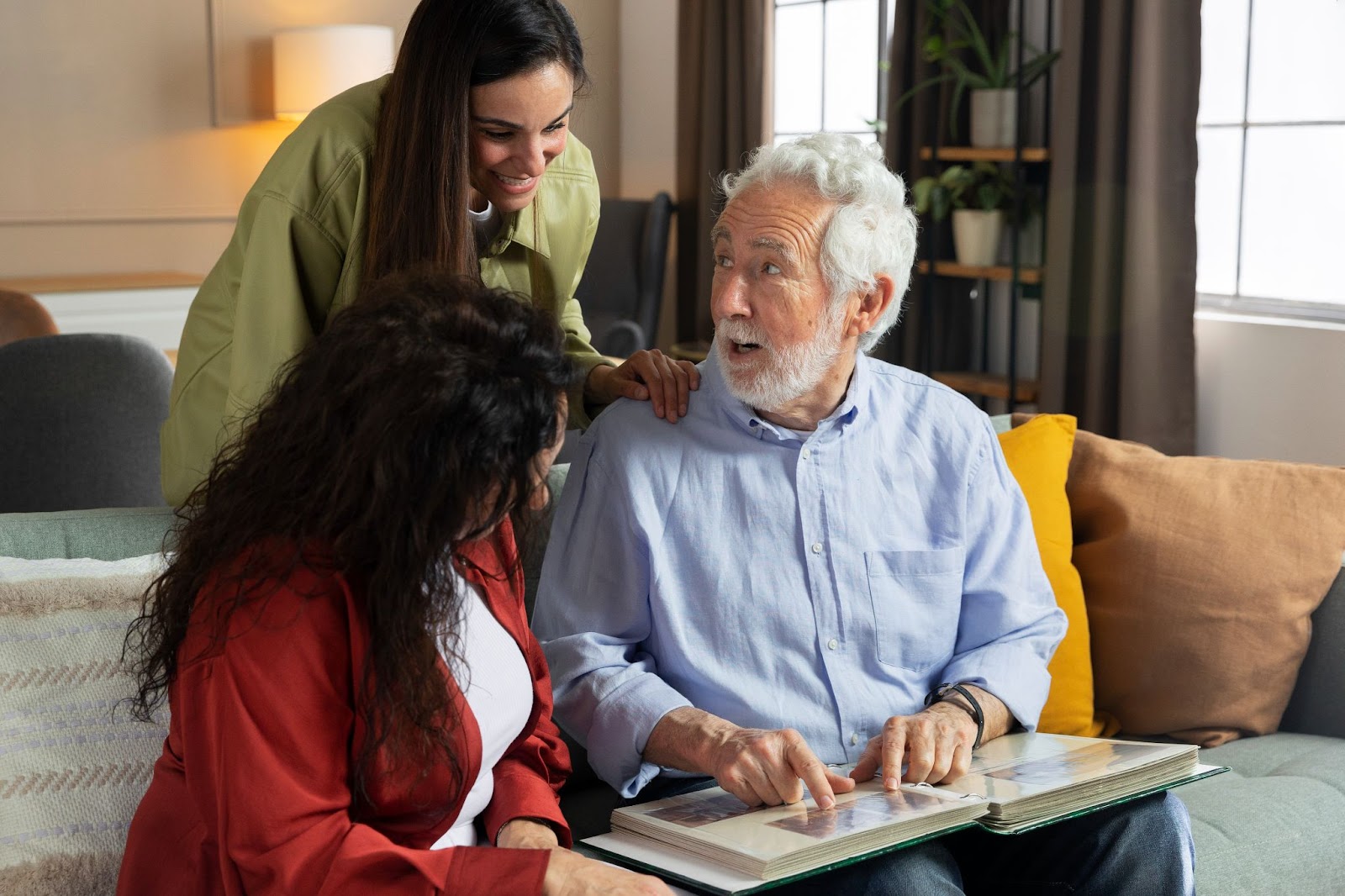 Older man sharing memories with family during cognitive therapy activity supporting mental well-being in aged care