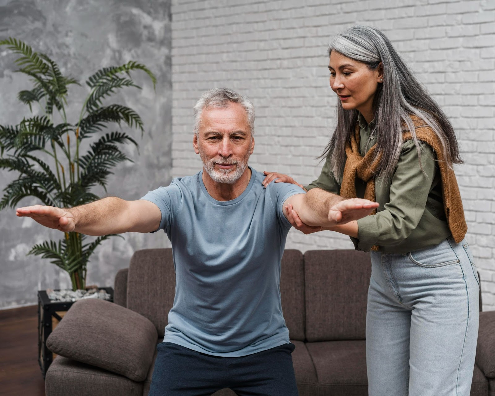 Senior man guided by physiotherapist performing balance exercises for arthritis management