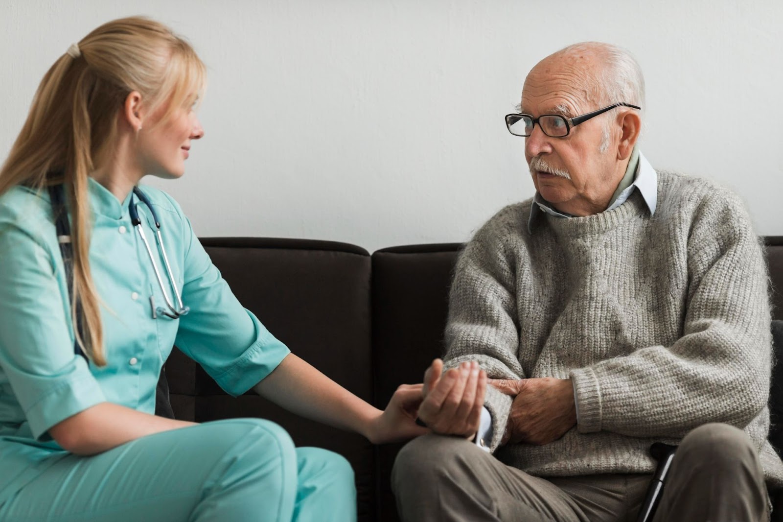Occupational therapist providing care through supportive conversation with elderly man