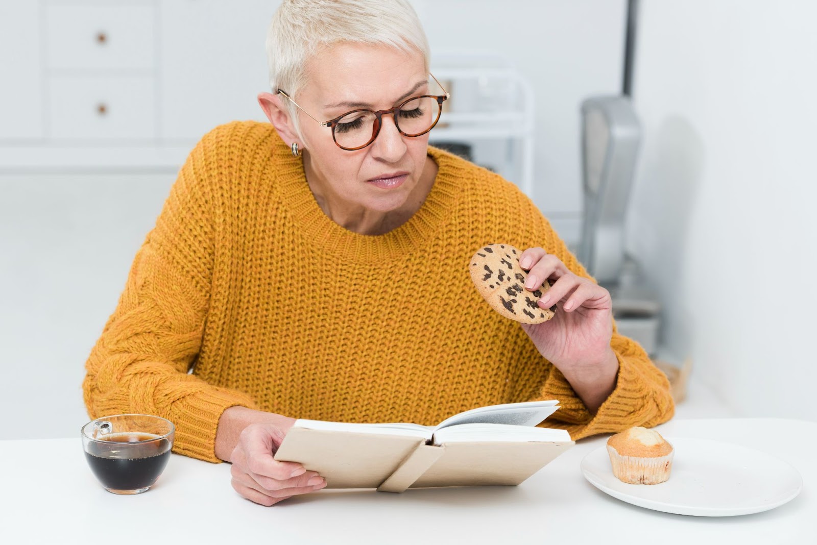 Senior woman distracted while eating a snack, demonstrating the importance of mindful eating in effective malnutrition treatment elderly strategies